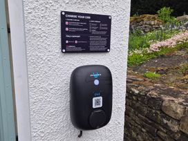 A charging station with instructions and QR code at Bramble Cottage in Thornthwaite near Braithwaite