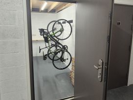 A bike mounted on a rack in a storage room at Bramble Cottage in Thornthwaite near Braithwaite