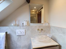 A bathroom with a glass sink and wall mounted faucet at Providence Farmhouse near Easingwold