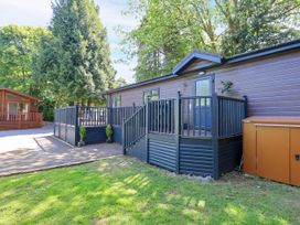 An outdoor view of a cabin with a fence and storage unit at Evermore Lodge, 48 Calgarth Park, White Cross Bay, Windermere
