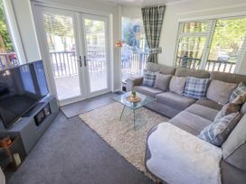 A living room with a television and sofa at Evermore Lodge 48 Calgarth Park, White Cross Bay, Windermere