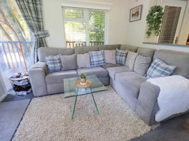 A living room with a sofa and coffee table at Evermore Lodge, 48 Calgarth Park, White Cross Bay, Windermere