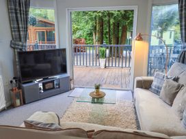 A living room with a television and a sofa at Evermore Lodge 48 Calgarth Park, White Cross Bay, Windermere