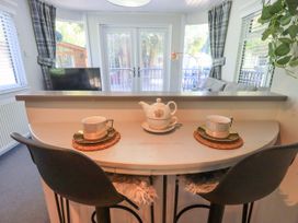 A dining area with a table set for tea at Evermore Lodge, 48 Calgarth Park, White Cross Bay, Windermere