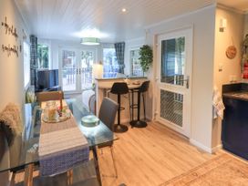 A kitchen with a dining area and bar seating at Evermore Lodge, 48 Calgarth Park, White Cross Bay, Windermere