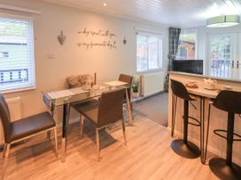 A dining area with a table and chairs at Evermore Lodge 48 Calgarth Park, White Cross Bay, Windermere