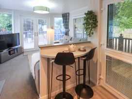 A living room with a television and seating area at Evermore Lodge, 48 Calgarth Park, White Cross Bay, Windermere