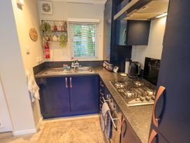 A kitchen with a stove and sink at Evermore Lodge 48 Calgarth Park, White Cross Bay, Windermere