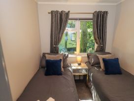 A bedroom with two single beds and a window at Evermore Lodge 48 Calgarth Park, White Cross Bay, Windermere