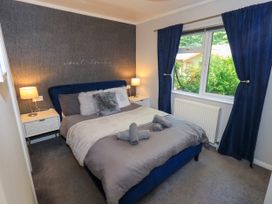 A bedroom with a bed and nightstand at Evermore Lodge 48 Calgarth Park, White Cross Bay, Windermere