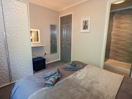 A bedroom with a bed and a dressing table at Evermore Lodge, 48 Calgarth Park, White Cross Bay, Windermere