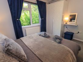 A bedroom with a bed and wardrobe at Evermore Lodge, 48 Calgarth Park, White Cross Bay, Windermere