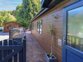 An outdoor area with wooden decking and a cabin at Evermore Lodge, 48 Calgarth Park, White Cross Bay, Windermere