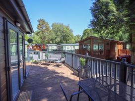 An outdoor area with decking and furniture at Evermore Lodge, 48 Calgarth Park, White Cross Bay, Windermere