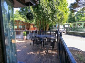 An outdoor deck with a table and chairs at Evermore Lodge, 48 Calgarth Park, White Cross Bay, Windermere