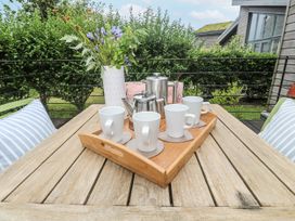 An outdoor seating area with a tray of mugs and teapot at Una, Lodge 70 in Carbis Bay