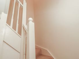 An indoor staircase with white wooden banisters and beige carpet at Primula Patch in Akeld near Wooler