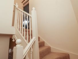 A carpeted staircase with white wooden banisters in a hallway at Primula Patch Akeld near Wooler