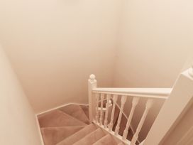 A staircase with carpeted steps and a white wooden railing at Primula Patch in Akeld near Wooler