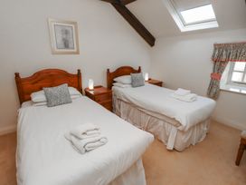 A bedroom with two single beds side by side and wooden headboards at Primula Patch in Akeld near Wooler