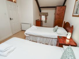 A bedroom with two single beds bedside table chest of drawers and wardrobe at Primula Patch Akeld near Wooler