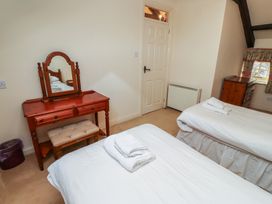 A bedroom with two single beds a wooden dressing table with a mirror and a stool at Primula Patch in Akeld near Wooler