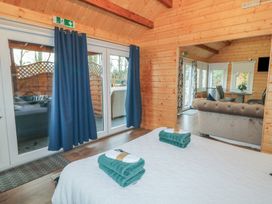 A bedroom with a bed and towels overlooking a living room with a sofa and dining table at Drumrane Lodge in Dungiven Londonderry
