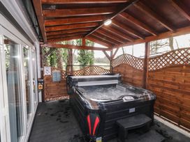 A covered outdoor area with a hot tub and wooden lattice fencing at Drumrane Lodge in Dungiven Londonderry