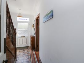 A hallway with a staircase and front door at Brynmorfa in Llandysul