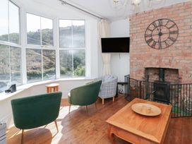 A living room with a fireplace and chairs at Brynmorfa in Llandysul