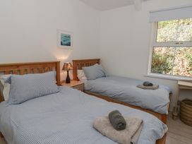 A bedroom with two single beds and a lamp at Brynmorfa in Llandysul