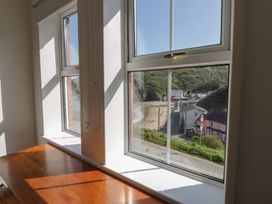 A view of houses and a beach from a window at Brynmorfa in Llandysul