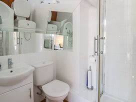 A bathroom with a sink, toilet, shower and mirror at Brynmorfa in Llandysul