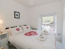 A bedroom with a bed, pillows, and a window at Brynmorfa in Llandysul