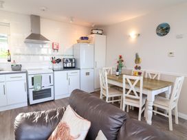 A kitchen with appliances and dining table at Castle View Lodge Ilfracombe
