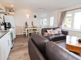 A living room with a dining area and kitchen at Castle View Lodge in Ilfracombe