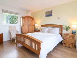 A bedroom with a bed and wooden furniture at Castle View Lodge in Ilfracombe
