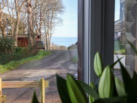A view of a road and water from a window at Castle View Lodge in Ilfracombe