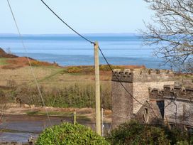 A coastal view with a building and vegetation at Castle View Lodge Ilfracombe