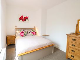 A bedroom with a bed and nightstand at Highland House in Sheringham