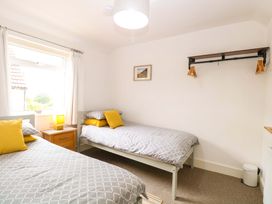 A bedroom with two beds and a window at Highland House in Sheringham