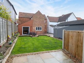 A garden with lawn and seating area at Highland House in Sheringham