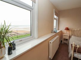 A bedroom with a view of the beach at 2 The Crescent