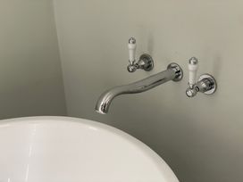 A bathtub with wall-mounted tap fixtures at Riverwash Cottage in Dwygyfylchi