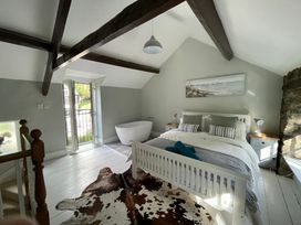 A bedroom with a bed and bathtub at Riverwash Cottage in Dwygyfylchi