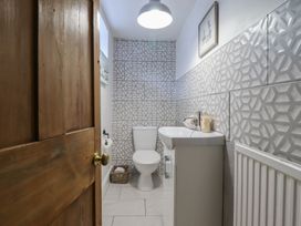 A bathroom with a toilet and sink at Riverwash Cottage Dwygyfylchi