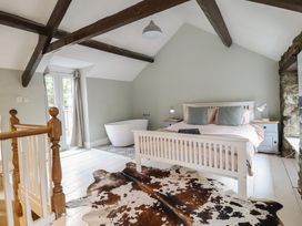 A bedroom with a bed and bathtub at Riverwash Cottage in Dwygyfylchi