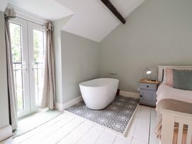 A bedroom with a bathtub and a bed at Riverwash Cottage in Dwygyfylchi