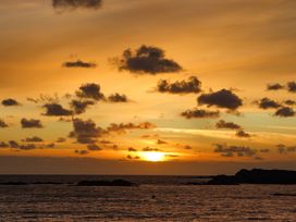 An ocean view with rocks and clouds during sunset at Seaddler in Trearddur Bay