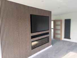 A living room with a television and fireplace at Seaddler in Trearddur Bay
